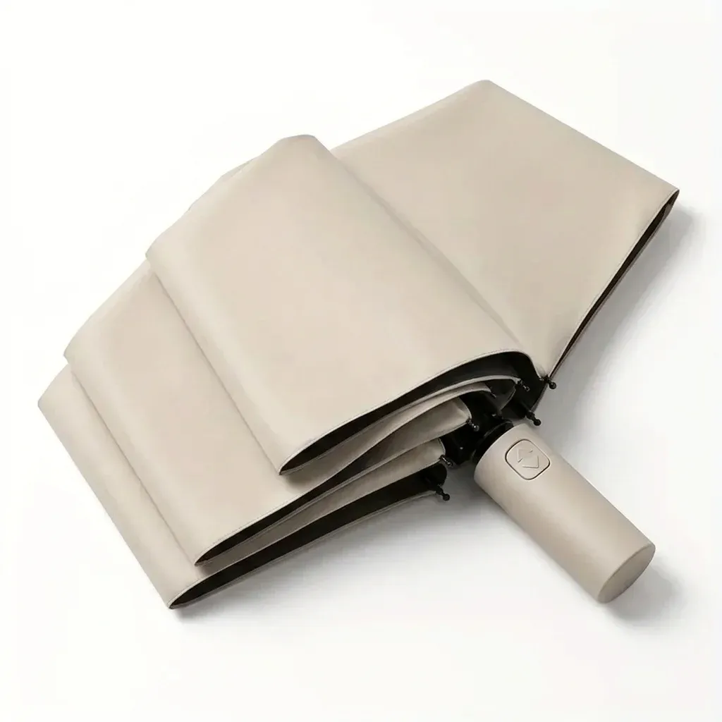 Beiger automatischer Faltregenschirm im Studio